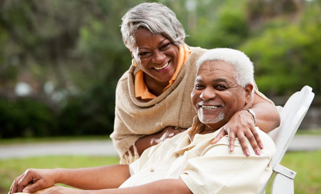 A retired couple embracing outdoors