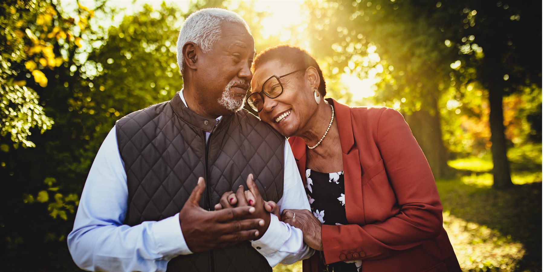 A retired couple embracing outdoors